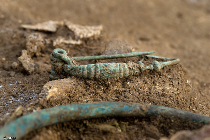 Detail view of a fibula, with a torc just visible in the foreground (© Denis Gliksman, Inrap)